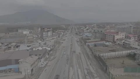 Aerial view of urban development and road infrastructure near mountains Stockbeeldmateriaal 327443149
