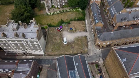 Aerial view of a vacant development plot beside a historic building, with Stock Footage 343468310