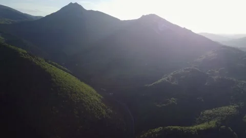 Aerial view of the valley below the mountain peaks in the glow of the setting Stock-Footage 195990777