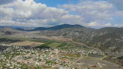Aerial view of the valley in front of the ridge. Colorful houses are located on Stock Footage 156525433