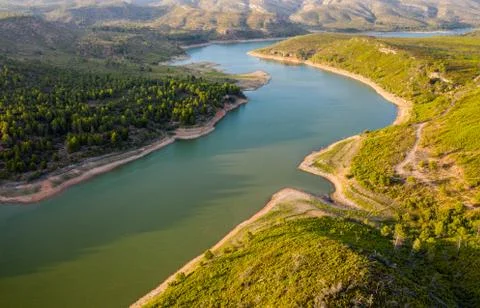 Aerial view of the valley, olive fields and Embalse de Forata reservoir during Stock Photos