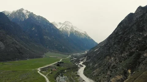 Aerial view of valley through which mountain river flows. Valley is covered with Vídeo Stock 157584553