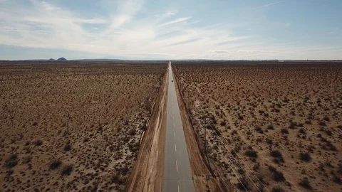 Aerial View of Van on the Road Surrounded by the Desert, Pan and Tracking Shot Stock Footage 129409023