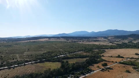 Aerial view of vast agricultural fields, countryside road and mountain horizon Stock Footage 341092685