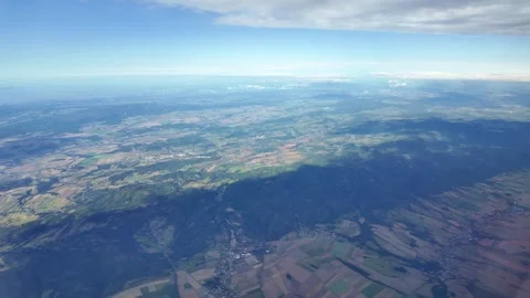 Aerial view of vast landscape with clouds casting shadows over rolling hills Stock Footage 331429644
