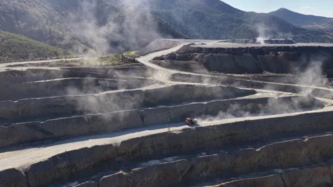 Aerial view of a vast open-pit mine and a massive mining dump truck operating Stock-Footage 345161852