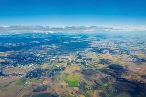 Aerial view of vast patchwork landscape with fields and cities under clear .. Foto stock