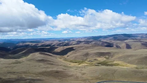 Aerial View of Vast Rolling Mountains and Plateau Landscape Under Blue Sky Video stock 342029311