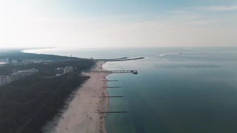 Aerial view of a vast sandy beach with pier and calm sea in Kołobrzeg Stock-Footage 336736672
