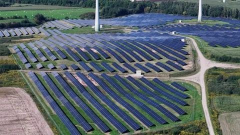 Aerial View of Vast Solar Panel Array and Wind Turbines in Green Countryside Vídeo Stock 346017351