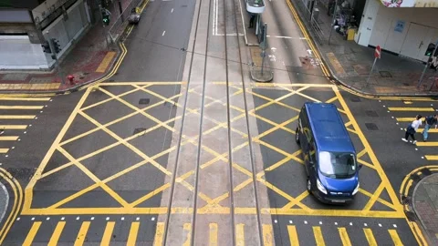 Aerial View of Vehicles Driving Through Yellow-Grid Intersection with Zebra Stock Footage 294506061