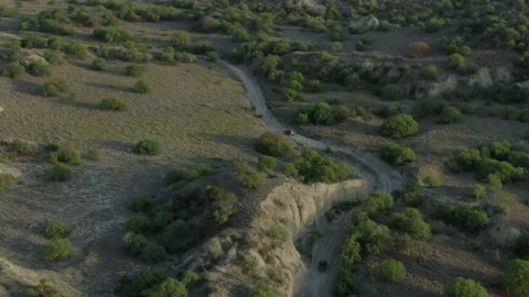 Aerial view, vehicles going up the hill with surreal landscape in Vashlovani Видео 238477963