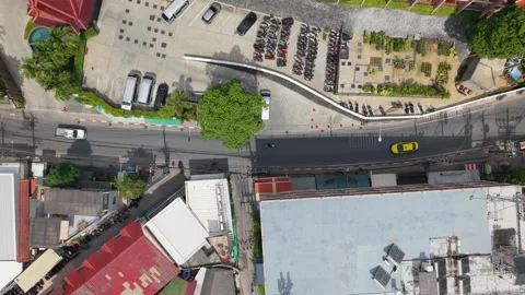 Aerial view of vehicles navigating urban street with greenery and buildings Vídeos de archivo 342332416