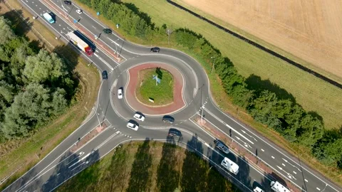 Aerial view of vehicles taking a two-lane roundabout in the countryside. Video stock 275444495