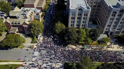 Aerial view of very large crowd marching in a protest in a city Stock Footage
