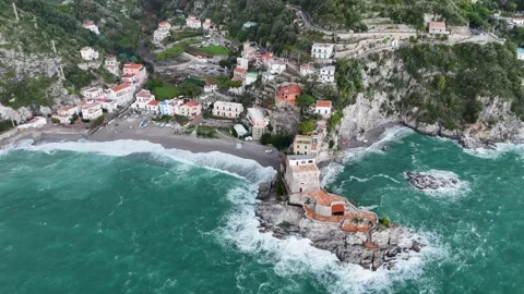 Aerial view of the vibrant Erchie beach with its historic coastal tower, set Stock Footage 325389277