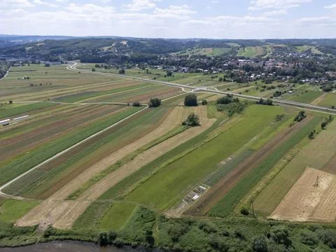 Aerial view of vibrant farmland with patchwork fields and a small village in the 스톡 사진