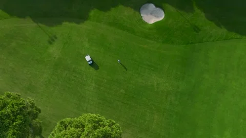 Aerial View: A vibrant golf course near luxury hotels, with players riding carts Stock Footage 296153025