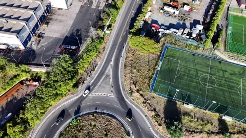 Aerial View of a Vibrant Roundabout Surrounded by Lush Greenery and Urban Stock Footage 280315434