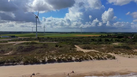 Aerial view video clip of sandy beach, marram grass dunes, wind turbines Stock Footage 341625316