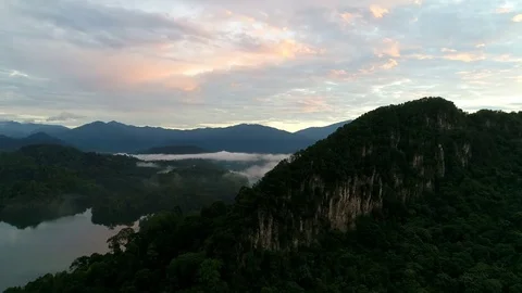 Aerial view. A view of limestone mountain peak, rain forest and lake. Video stock 83310464