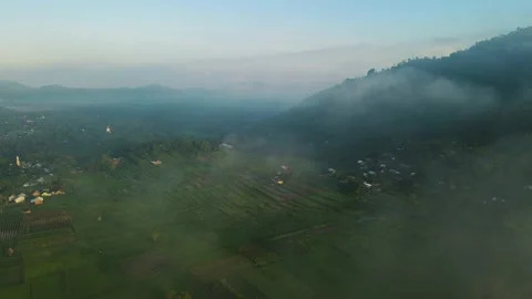 Aerial view, a view of rice fields and hills shrouded in mist in the morning Stock Footage 188395996