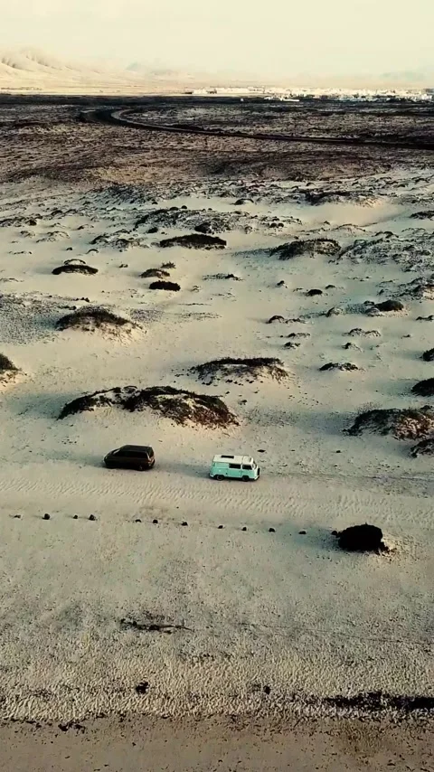 Aerial view of a vintage camper van and a modern suv driving together through a Stock Footage 344838428