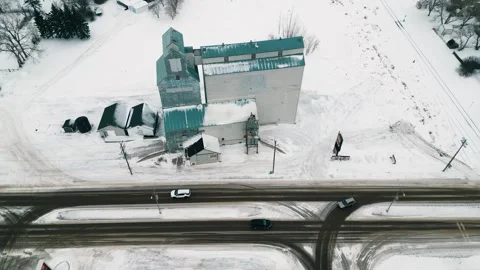 Aerial view of vintage grain elevator under gentle winter snowfall Stock Footage 296626451