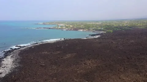 Aerial View of Volcanic Lava Fields Transitioning to Lush Green Neighborhood Stock Footage 328389208