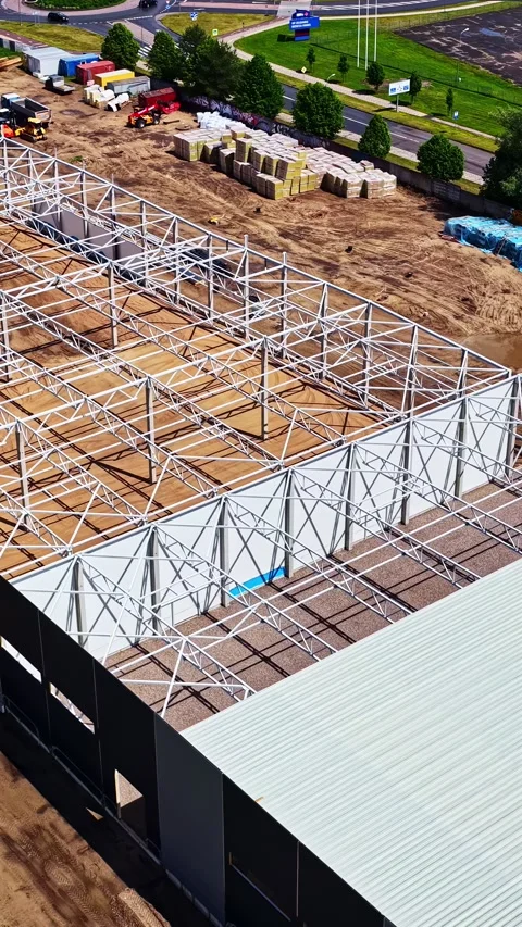 Aerial view of warehouse building and steel frame construction site Stock Footage 339646834