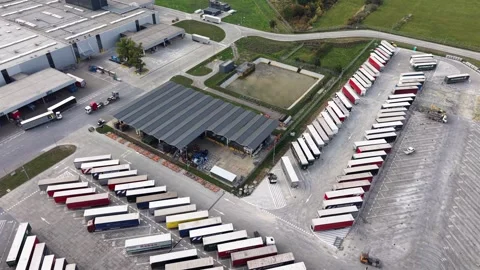 Aerial view of warehouse complex with rows of parked lorry trailers Video stock 347414201