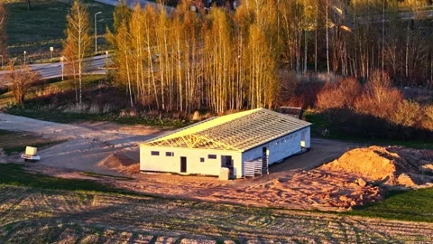 Aerial view of a warehouse construction site with a wooden roof framing at Vidéo 336697143