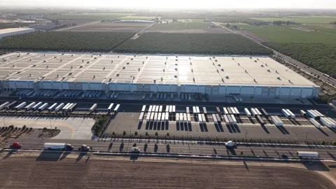 Aerial View of Warehouse Logistics Center with Trucks and Vast Farmland at Stock Footage 345802284