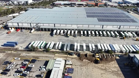 Aerial view of a warehouse logistics hub with trucks and solar panels Video stock 341918514