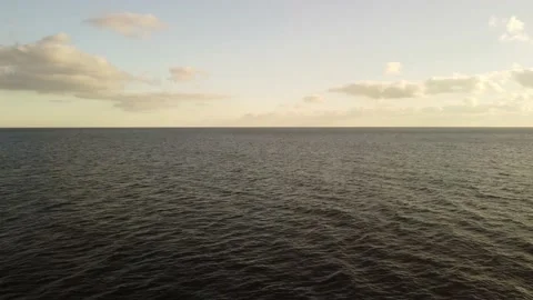 Aerial view on warm sunset over calm sea. Small waves on water surface in motion Stock Footage 221678063