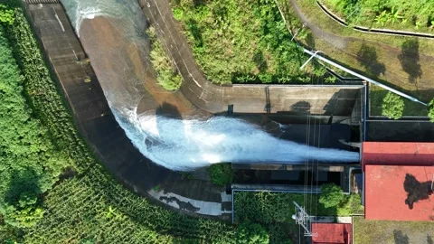Aerial View of Water Flowing Through Open Gate of a Small Dam Stock Footage 309917547