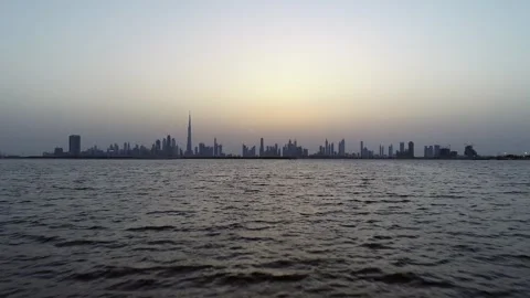 Aerial view at water level of Dubai skyscrapers and bay at sunset. Stock Footage 345224439