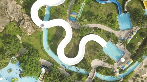 Aerial view water slide in amusement aquapark. People having fun riding on Stock Footage 106987403
