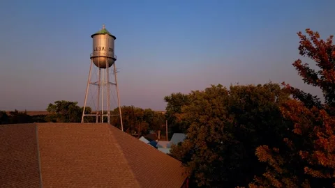 Aerial view of the water tower at sunset over the town Vídeos de archivo 345531505
