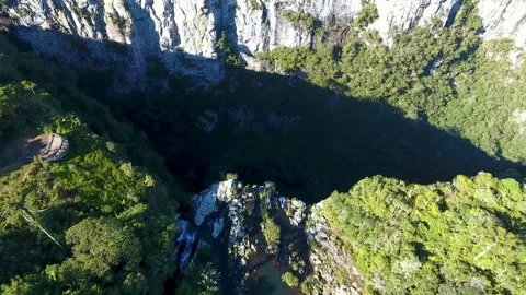 Aerial view of waterfall cascading over rocky cliff into deep canyon. Stock-Footage 341396242