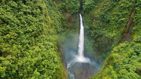 Aerial view of a waterfall dropping powerfully into a misty pool in the forest Stock-Footage 327610999