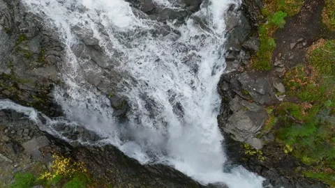 Aerial view of waterfall flowing through rocky forest terrain Stock Footage 309322384