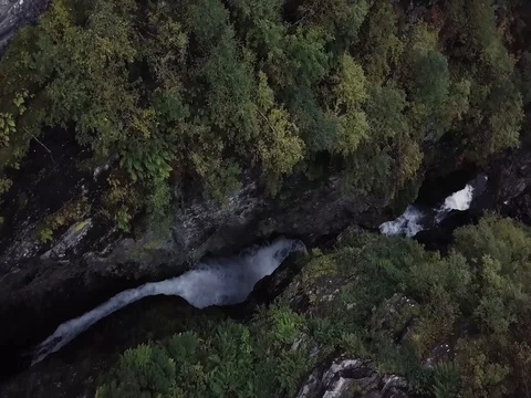 Aerial View of Waterfall Flowing with Trees in Forest in Norway Видео 82981165