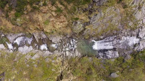 Aerial view of waterfall flowing trough rocks of mountain. On both side green Stock Footage 202008295