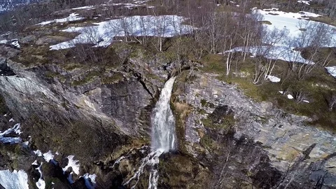 Aerial view of Waterfall from Mountain surrounded by trees and snow 動画素材 92992985