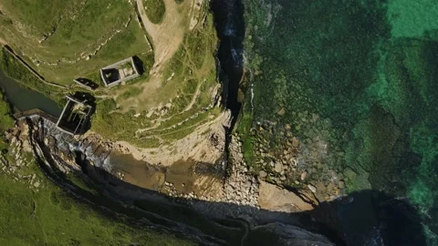 Aerial view of waterfall, with old mills next door, flowing into the sea Stock Footage 166199318