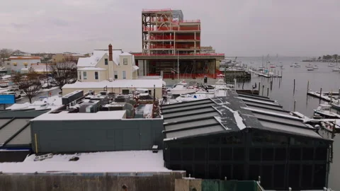Aerial view of waterfront construction site in winter snow, ProRes 422HQ footage 库存影片 332703983