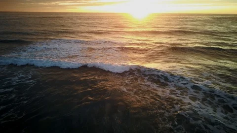 Aerial view of a wave that breaks on the beach at sunset Stock Footage 119782782