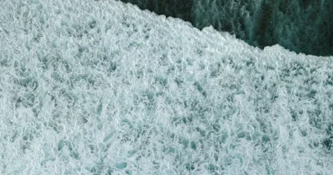 Aerial view of a wave crashing on winter beach covered in snow Stock Footage 270791707