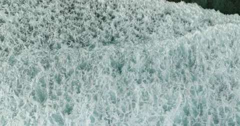 Aerial view of a wave crashing on winter beach covered in snow Stock Footage 271233981
